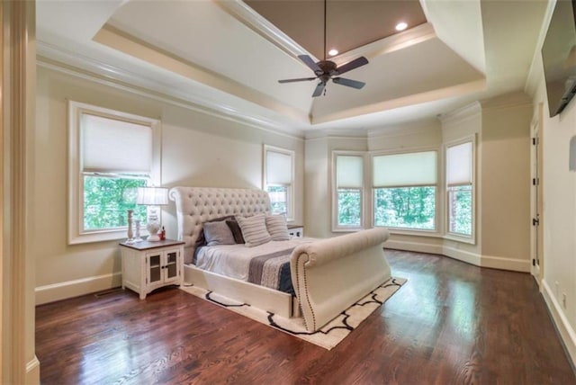 bedroom with a tray ceiling, ceiling fan, dark wood-type flooring, and crown molding