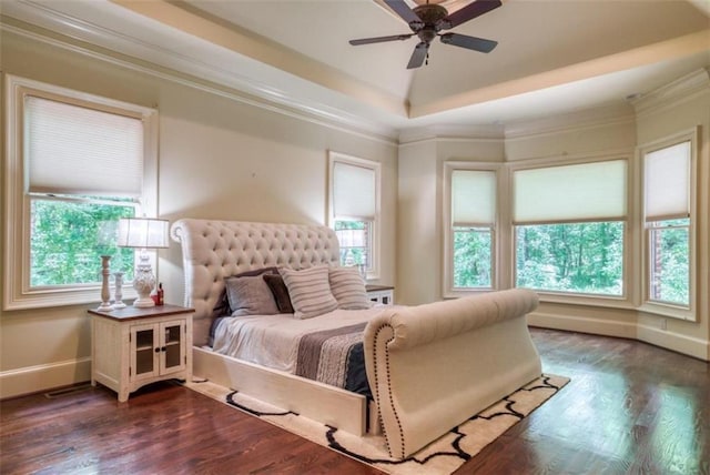 bedroom with dark hardwood / wood-style flooring, ceiling fan, a raised ceiling, and crown molding