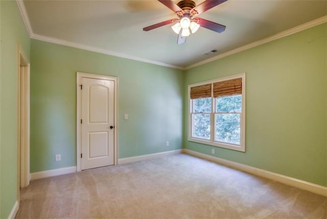 empty room with ceiling fan, crown molding, and light colored carpet