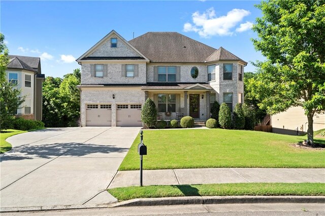 view of front of house featuring a porch, a garage, and a front lawn