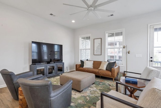 living room featuring light hardwood / wood-style floors and ceiling fan