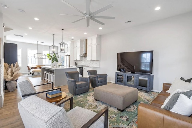 living room with ceiling fan and light hardwood / wood-style floors