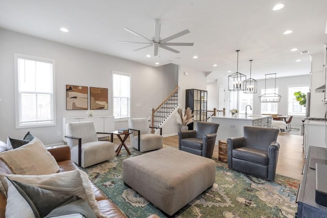 living room with light hardwood / wood-style flooring and ceiling fan