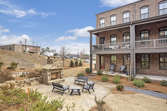 back of house featuring a patio and an outdoor stone fireplace