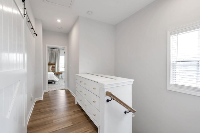 corridor featuring a barn door and light wood-type flooring