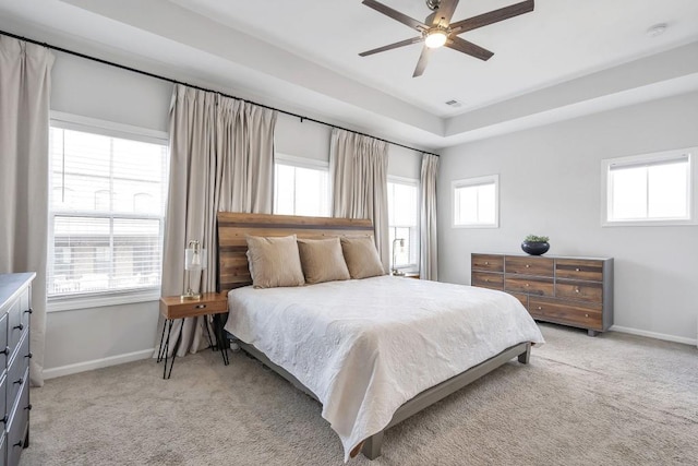 bedroom featuring ceiling fan, multiple windows, and light carpet