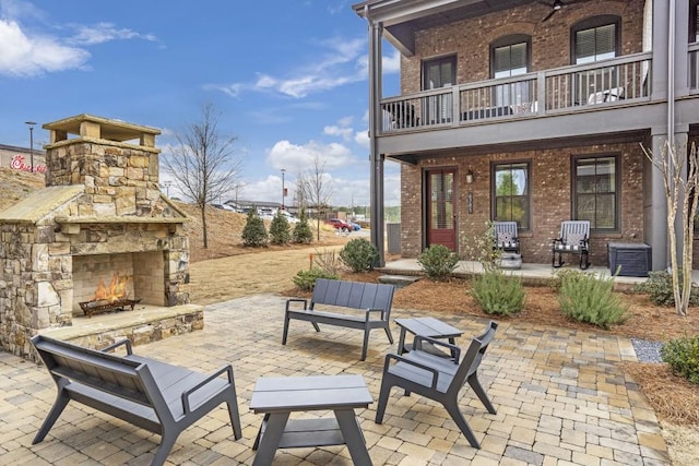 view of patio featuring an outdoor stone fireplace