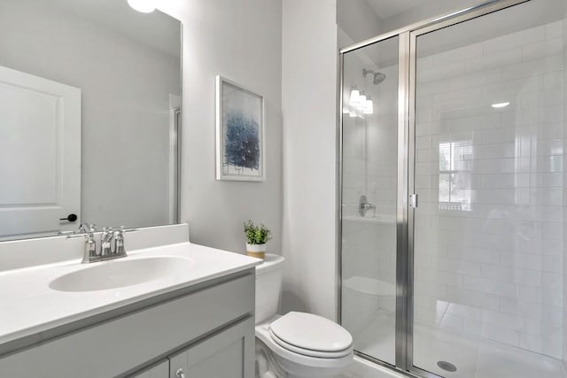 bathroom featuring vanity, toilet, and walk in shower