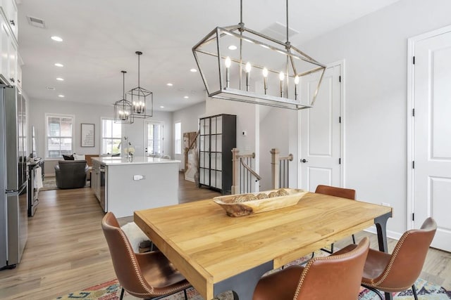 dining room with a chandelier and light wood-type flooring