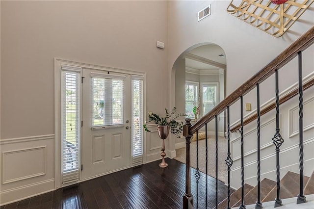 1405 Rainey Way, Hampton, GA 30228 - foyer entrance featuring wood-type flooring, arched walkways, a high ceiling, a decorative wall, and stairs