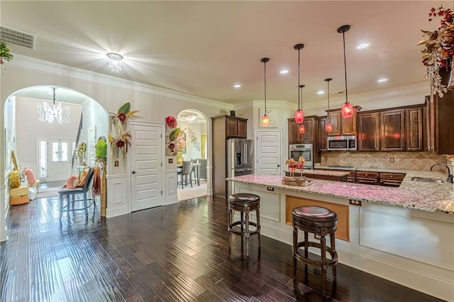 1405 Rainey Way, Hampton, GA 30228 - kitchen featuring stainless steel appliances, arched walkways, light stone countertops, a breakfast bar area, and a peninsula