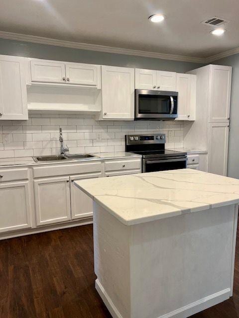 kitchen with white cabinetry, appliances with stainless steel finishes, sink, and light stone counters