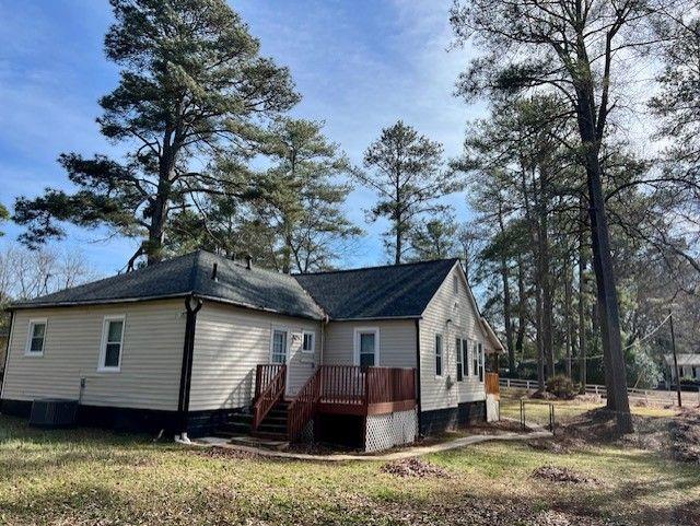 view of side of property featuring central AC and a deck