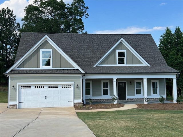 craftsman inspired home with covered porch, a garage, and a front lawn