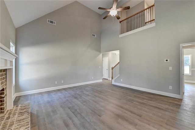 unfurnished living room featuring high vaulted ceiling, a fireplace, ceiling fan, and hardwood / wood-style floors