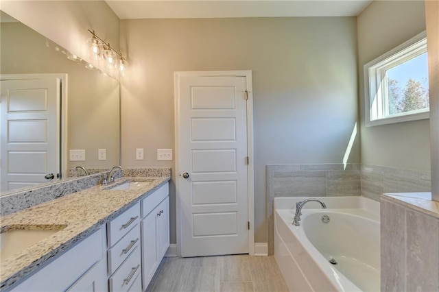 bathroom with double vanity, tile patterned flooring, and a tub