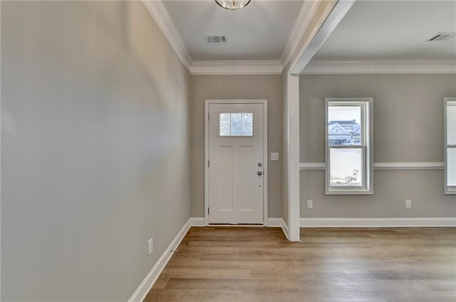 foyer with crown molding and light hardwood / wood-style flooring