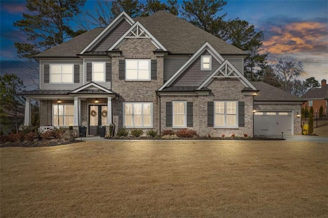 view of front facade with a garage, a front lawn, a standing seam roof, and brick siding