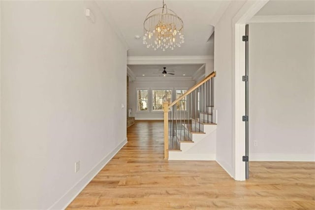 interior space featuring crown molding, stairway, baseboards, and wood finished floors