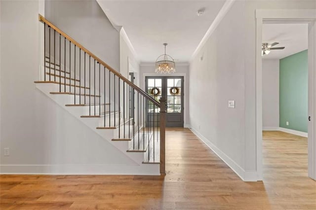 entrance foyer featuring baseboards, stairway, wood finished floors, and ornamental molding