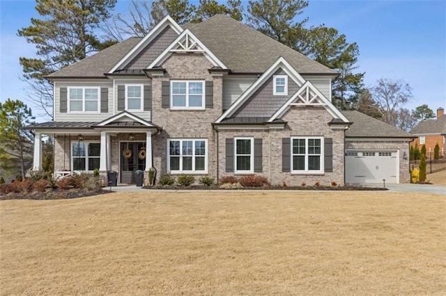 craftsman-style house featuring a garage, a front yard, and a standing seam roof