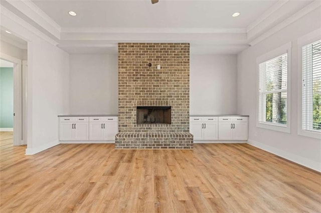 unfurnished living room with recessed lighting, a brick fireplace, light wood-style flooring, and baseboards