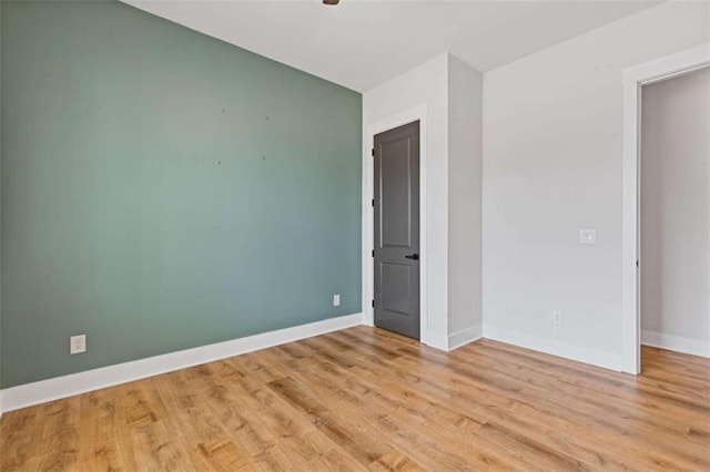 empty room with light wood-style flooring and baseboards