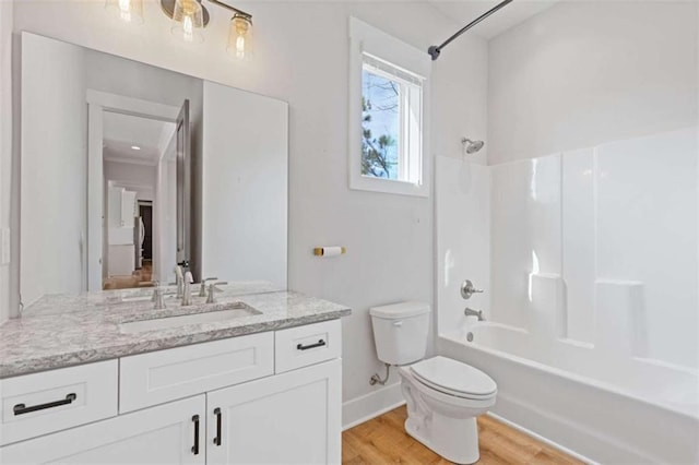 bathroom featuring shower / tub combination, toilet, wood finished floors, vanity, and baseboards