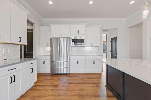 kitchen with stainless steel appliances, light wood-style floors, white cabinetry, and crown molding