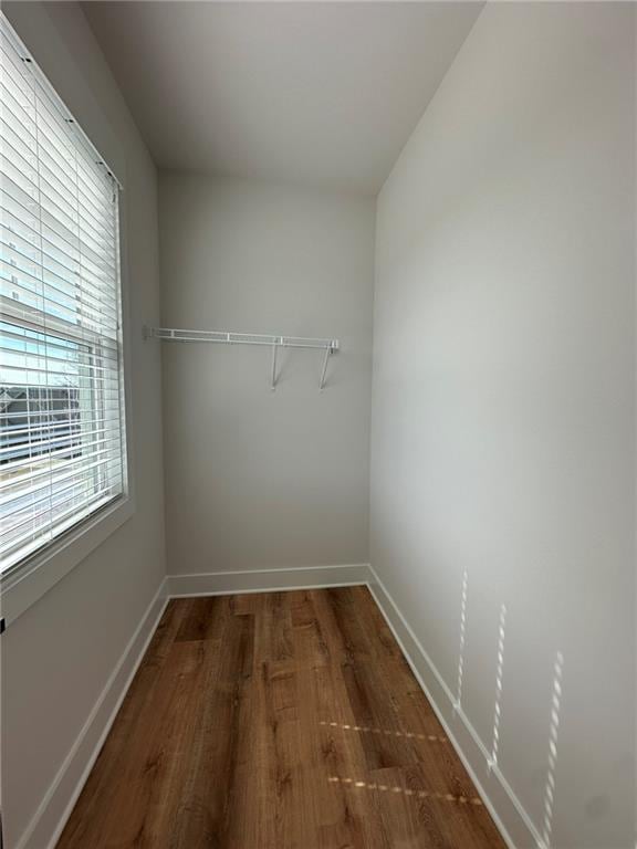 walk in closet with wood finished floors