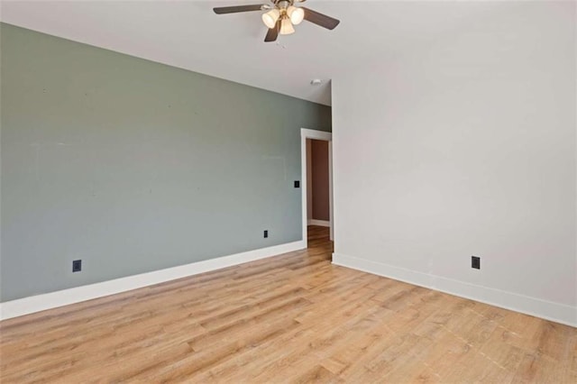 spare room with light wood-style floors, baseboards, and a ceiling fan