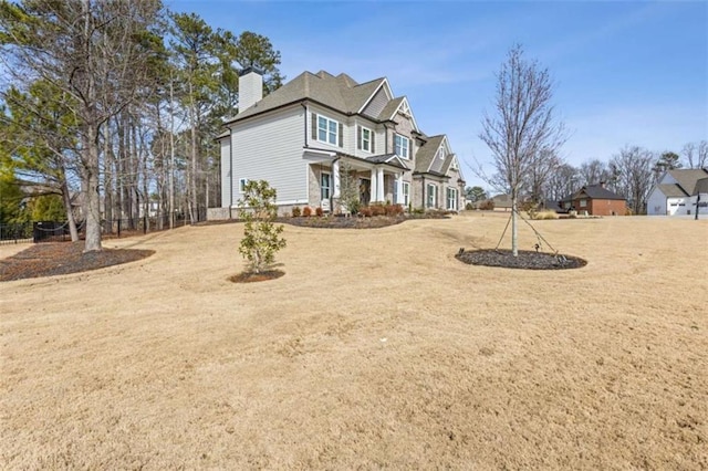 view of front of property with a chimney and a front lawn