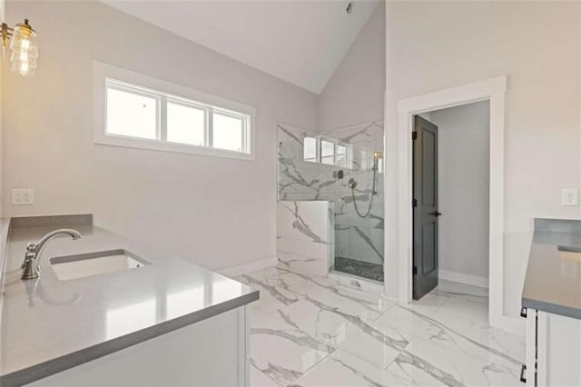 bathroom with lofted ceiling, vanity, baseboards, marble finish floor, and a marble finish shower