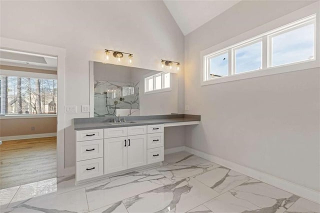 bathroom with lofted ceiling, plenty of natural light, a marble finish shower, and vanity