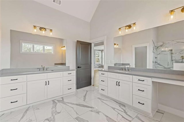 full bathroom with a marble finish shower, visible vents, two vanities, and a sink