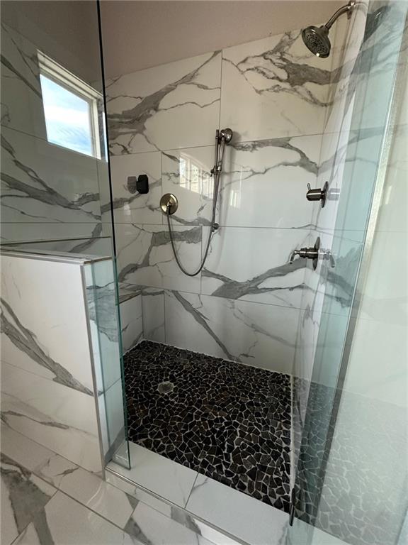 bathroom with a marble finish shower