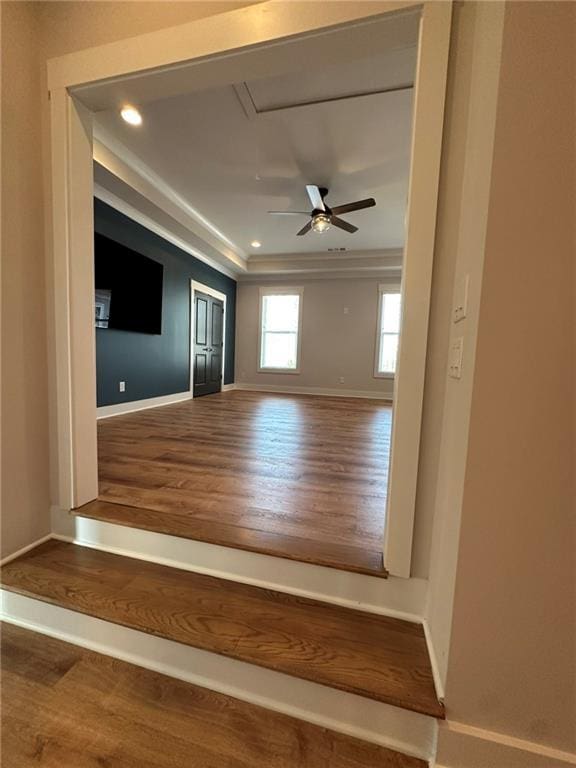 unfurnished living room with baseboards, a ceiling fan, ornamental molding, wood finished floors, and recessed lighting