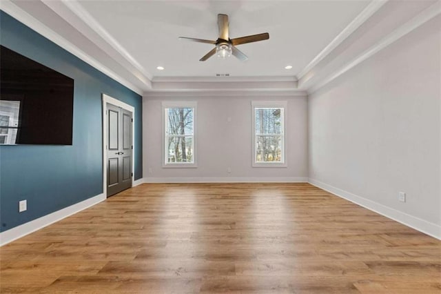 interior space featuring a tray ceiling, light wood-style flooring, baseboards, and recessed lighting