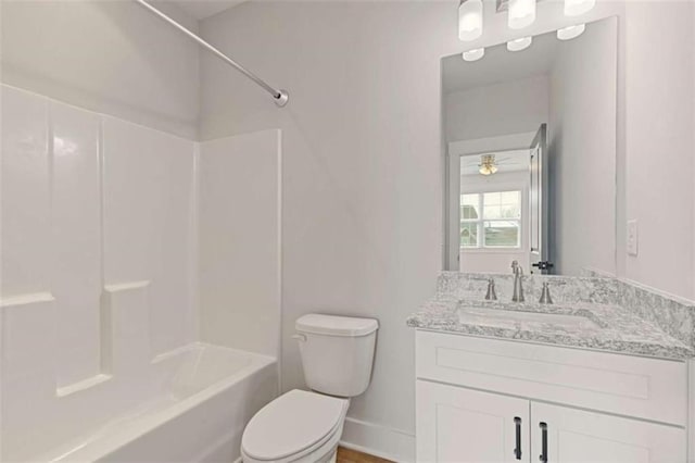 bathroom featuring toilet, shower / bathtub combination, baseboards, and vanity