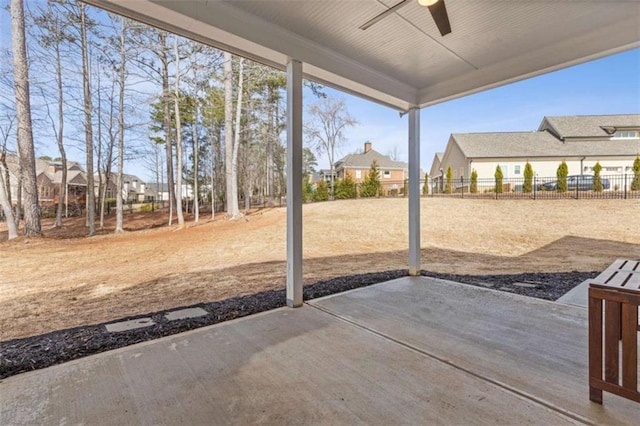 view of patio / terrace featuring a ceiling fan, a residential view, and fence