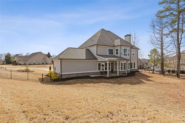 rear view of property with a chimney, a patio area, and fence