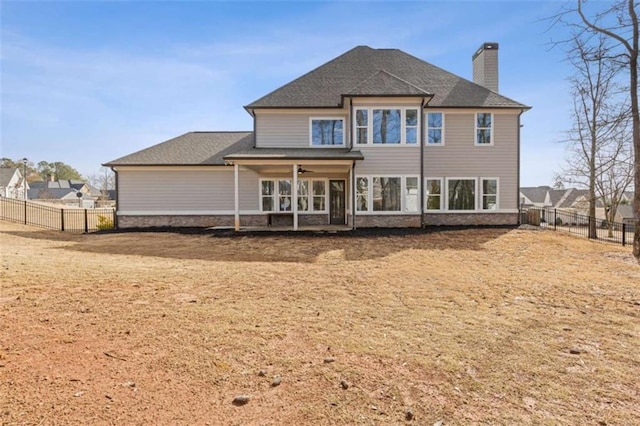 rear view of property featuring a fenced backyard, a chimney, and a ceiling fan