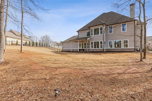 back of property featuring a chimney and fence