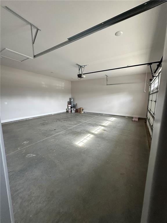 garage featuring a garage door opener and baseboards