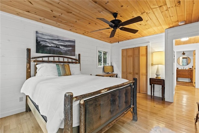 bedroom featuring ceiling fan, wood ceiling, light wood-type flooring, and wood walls