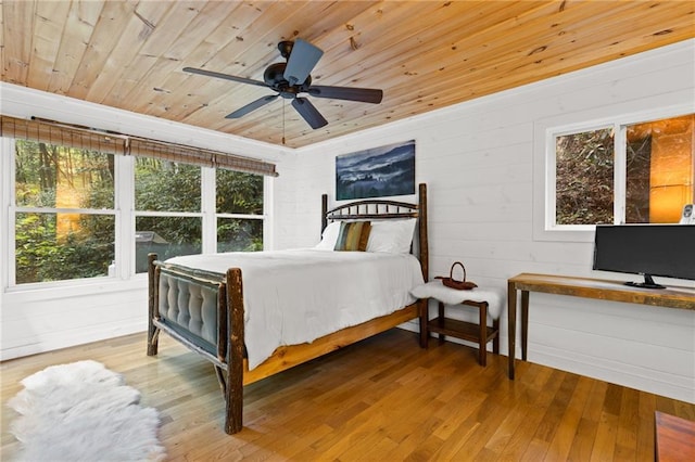 bedroom with wood walls, ceiling fan, hardwood / wood-style flooring, and wood ceiling