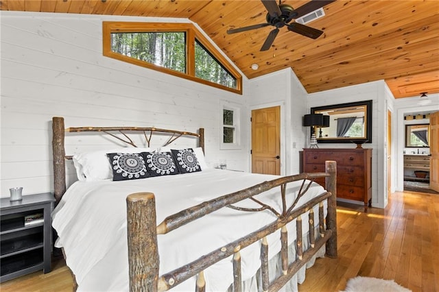 bedroom featuring wood ceiling, light wood-type flooring, wooden walls, and vaulted ceiling