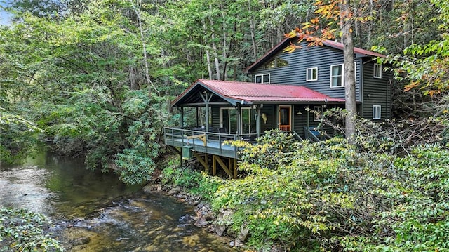 back of property featuring a water view