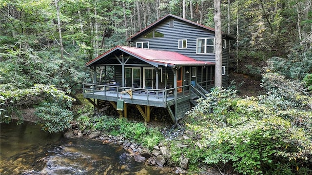 back of house with a deck with water view