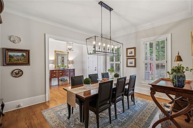 dining room featuring ornamental molding, wood finished floors, and baseboards